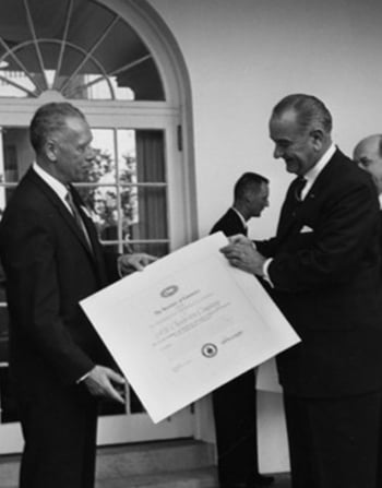 1964 - President Lyndon B. Johnson awards Dev Chesterton the 500th “E” award
